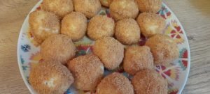 Papanasși pronti în tigaie, ideali pentru mic dejun sau desert, garnisiți cu miere, dulceață, smântână, fructe proaspete sau sos de fructe