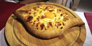 Video: Khachapuri, tradiționala mâncare georgiană asemănătoare unei pizze, cu aluat în formă de bărcuță, umplut cu brânză gratinată și ou moale