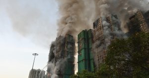 Pentru a reformula titlul dat, am să folosesc sinonime și expresii alternative pentru a descrie evenimentul:

“Un incendiu devastator a izbucnit în Hong Kong, rezultând în patru decese și lăsând numeroase persoane blocate într-un ansamblu de clădiri aflate în proces de renovare, caracterizat prin utilizarea unor schele din bambus.”

Am înlocuit “uriaș” cu “devastator” pentru a adăuga o notă de gravitate evenimentului, iar “complex de blocuri” a fost schimbat în “ansamblu de clădiri” pentru a oferi o imagine mai generală a locației. De asemenea, am menționat utilizarea “schelelor din bambus” pentru a păstra detaliul specific al împrejurărilor, fără a face referire la niciun site extern.
