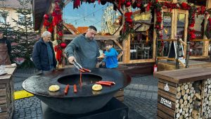 La Târgul de Crăciun din Sibiu, poți să-ți gătești singur cârnații pe o plită cu lemne încălzită