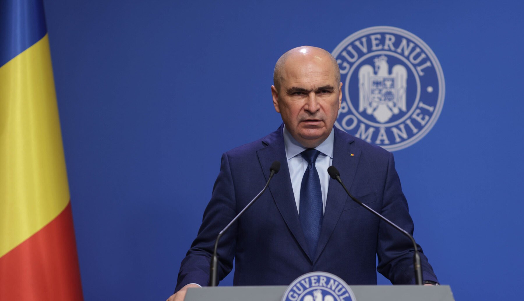 Bolojan anunță că în anul următor nu vor avea loc majorări de taxe, mulțumește românilor pentru situația actuală, stabilește plafonarea creșterii salariilor în companiile de stat pentru 2026 și menționează reducerea cheltuielilor administrative prin disponibilizări.
