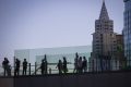 People cross a pedestrian bridge along the Las Vegas Strip during Labor Day weekend on Sunday, ...