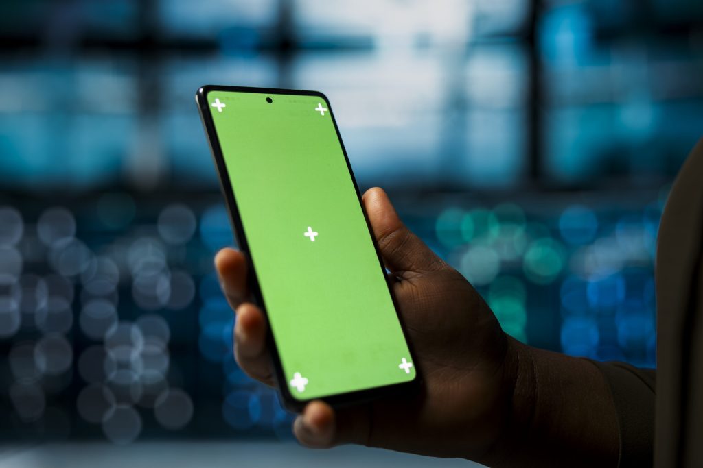 close-up-data-center-system-administrator-using-green-screen-smartphone-optimize-network-scaled.jpg