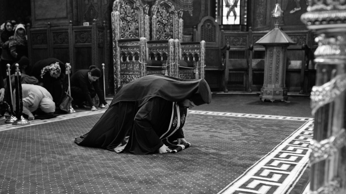 preot ortodox in genunchi biserica romania saptamana mare