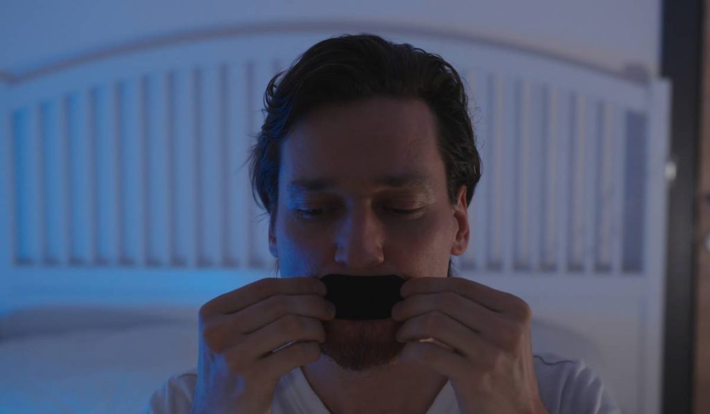 Medic șocant: Își lipește gura pentru somn liniștit. Metoda bizară